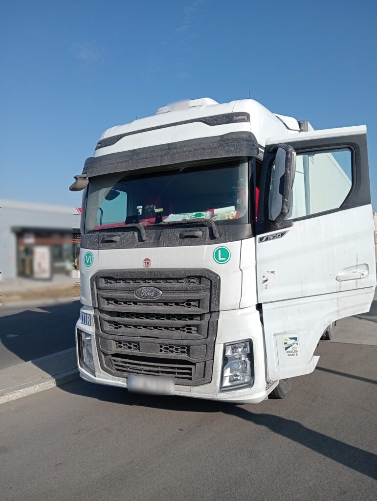 Biała ciężarówka Ford zaparkowana na parkingu w słoneczny dzień.