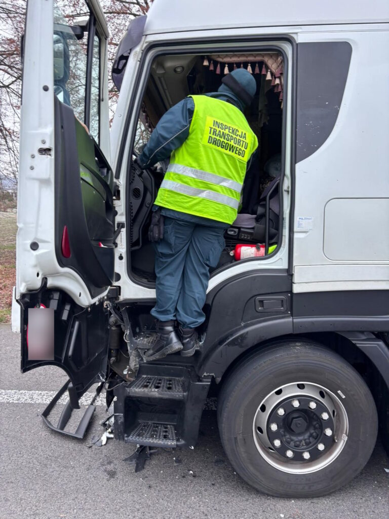 Funkcjonariusz Inspekcji Transportu Drogowego kontroluje uszkodzoną kabinę ciężarówki