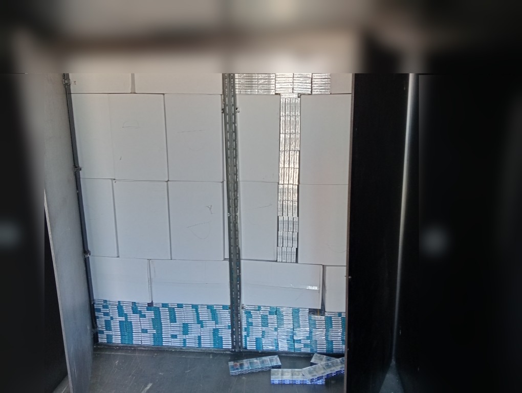 Wnętrze pojazdu dostawczego z ukrytym ładunkiem ułożonym za płytami maskującymi.