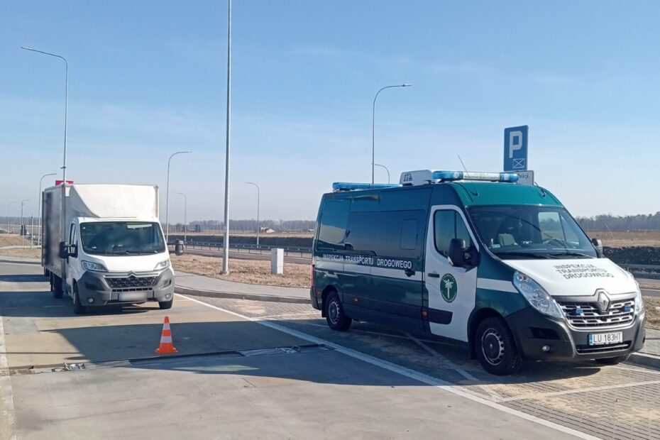 Pojazd Inspekcji Transportu Drogowego zatrzymał dostawczy samochód do kontroli na punkcie wagowym przy drodze.