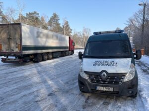 Pojazd Inspekcji Transportu Drogowego zatrzymał dostawczy samochód do kontroli na punkcie wagowym przy drodze.