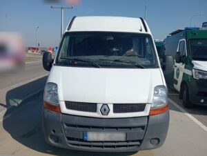 „Biały samochód dostawczy zatrzymany do kontroli drogowej na poboczu w ciągu dnia”