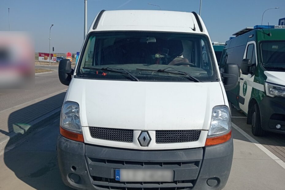 „Biały samochód dostawczy zatrzymany do kontroli drogowej na poboczu w ciągu dnia”