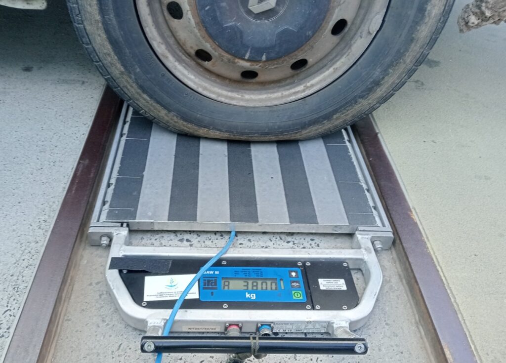 „Koło pojazdu na wadze kontrolnej – pomiar nacisku osi wynoszący 3800 kg”
